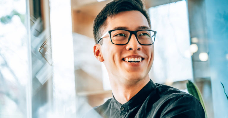 Smiling man in an office, suggesting creation of intellectual property